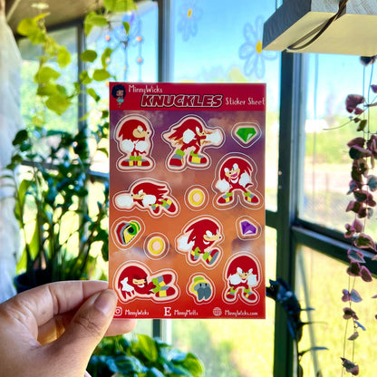 Hand holding a package of Knuckles stickers in front of a window with plants